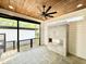 Modern covered porch with fireplace, ceiling fan, and stone flooring, creating a cozy outdoor space at 622 Glascock St, Raleigh, NC 27604