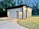 Twilight view of detached garage with large glass window, white door and siding, with black trim at 622 Glascock St, Raleigh, NC 27604