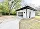 Detached garage with white siding, black trim, an attached driveway, and mature trees at 622 Glascock St, Raleigh, NC 27604