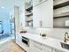 Bright kitchen features white cabinets, modern appliances, quartz counters, and beautiful open shelving at 622 Glascock St, Raleigh, NC 27604