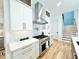 White cabinets, stainless steel appliances, marble countertops and hardwood floors in kitchen at 622 Glascock St, Raleigh, NC 27604