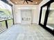 Covered outdoor patio with a stone fireplace, tiled floors, and a view of the backyard at 622 Glascock St, Raleigh, NC 27604
