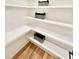 Pantry with hardwood floors and white shelves with decorative storage baskets at 622 Glascock St, Raleigh, NC 27604