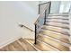 Modern staircase featuring wood steps, black railings and white risers, with white walls and wood floors at 622 Glascock St, Raleigh, NC 27604