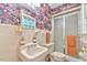 Bathroom boasting colorful floral wallpaper, a stylish sink, and a glass-enclosed shower, blending style with functionality at 775 Old Graham Rd, Pittsboro, NC 27312