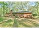 Brick home exterior with a chimney, sliding glass doors, and level backyard at 775 Old Graham Rd, Pittsboro, NC 27312