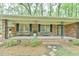 Inviting front porch with brick detail, black shutters, and seating area at 775 Old Graham Rd, Pittsboro, NC 27312