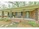 Inviting front porch with brick detail, black shutters, and seating area at 775 Old Graham Rd, Pittsboro, NC 27312