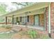Inviting front porch with brick detail, black shutters, and seating area at 775 Old Graham Rd, Pittsboro, NC 27312