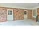 Covered outdoor porch featuring brick siding and multiple access doors at 775 Old Graham Rd, Pittsboro, NC 27312