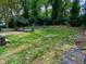 Large backyard space with established planting beds and wooded area in the background at 810 Nancy St, Durham, NC 27701