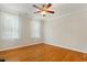 Cozy bedroom featuring hardwood floors, two windows, and a ceiling fan for comfort at 83 Calabria Ct, Clayton, NC 27527