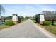 Long driveway leading to the property entrance, with gated entry and lush greenery on either side at 83 Calabria Ct, Clayton, NC 27527