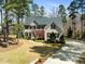 Beautiful brick home with a well-manicured front lawn, driveway, and mature trees at 83 Calabria Ct, Clayton, NC 27527