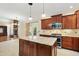 Open-concept kitchen with a view of the fireplace, featuring granite countertops and modern appliances at 83 Calabria Ct, Clayton, NC 27527