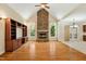 Living room featuring a stone fireplace, hardwood floors, built-in cabinets, and large windows at 83 Calabria Ct, Clayton, NC 27527