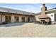 Elegant outdoor patio with a stone fireplace, comfortable seating, and access to the home's interior at 83 Calabria Ct, Clayton, NC 27527