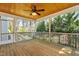 Relaxing screened-in porch with wooden floors, a ceiling fan, and views of the backyard trees at 83 Calabria Ct, Clayton, NC 27527