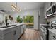 Bright kitchen with stainless steel appliances, gray cabinets, wood floors, and backyard view at 834 Day Ave, Burlington, NC 27217