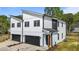 Modern two-story home featuring a white and black color scheme and an attached garage with black door at 836 Day Ave, Burlington, NC 27217