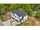 A modern two-story duplex with attached garages and concrete driveway, set against a backdrop of lush trees at 836 Day Ave, Burlington, NC 27217