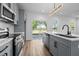 Bright kitchen featuring modern gray cabinets, stainless steel appliances, and a sliding glass door to the backyard at 836 Day Ave, Burlington, NC 27217