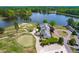 Panoramic aerial view of a golf course and clubhouse complex by a scenic lake at 8409 Muirfield Dr, Fuquay Varina, NC 27526