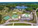 Aerial view of the golf course, tennis courts, clubhouse and pool with a lake view at 8409 Muirfield Dr, Fuquay Varina, NC 27526