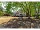 A two-story brick home is partially shaded by a large tree at 8409 Muirfield Dr, Fuquay Varina, NC 27526