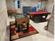 Recreational basement with pool table, foosball table, brick walls and a patterned rug at 910 Old Orchard Rd, Chapel Hill, NC 27517