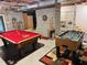 Finished basement featuring a pool table, foosball table, and exposed brick at 910 Old Orchard Rd, Chapel Hill, NC 27517