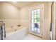 Bright bathroom featuring a soaking tub and access to a private porch with ample sunlight at 910 Old Orchard Rd, Chapel Hill, NC 27517