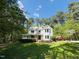 Beautiful two-story white home with a metal roof and a welcoming front porch, surrounded by trees at 910 Old Orchard Rd, Chapel Hill, NC 27517