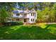 Charming two-story home with a metal roof, front porch, and landscaped front yard surrounded by lush trees at 910 Old Orchard Rd, Chapel Hill, NC 27517