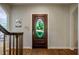 Beautiful foyer with hardwood floors, elegant staircase, and a charming front door at 910 Old Orchard Rd, Chapel Hill, NC 27517