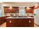 Charming kitchen with island cooktop, cherry cabinetry, white countertops, and tile backsplash at 910 Old Orchard Rd, Chapel Hill, NC 27517