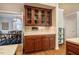 Kitchen with glass-front cabinets, breakfast bar and cherry wood cabinets, open to dining area at 910 Old Orchard Rd, Chapel Hill, NC 27517