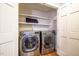 Bright laundry closet with modern, stainless steel washer and dryer and white shelving at 910 Old Orchard Rd, Chapel Hill, NC 27517