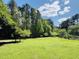 Picturesque view of a sprawling green yard with mature trees and landscaping, offering privacy and tranquility at 910 Old Orchard Rd, Chapel Hill, NC 27517