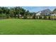 Spacious backyard with lush green lawn, landscaping, and a black fence surrounding the perimeter at 921 Lily Claire Ln, Fuquay Varina, NC 27526