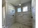 Spa-like bathroom featuring multiple shower heads, a niche, and decorative wall tile at 921 Lily Claire Ln, Fuquay Varina, NC 27526