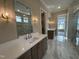 Luxurious bathroom with double sink vanities, large mirrors, modern fixtures, and beautiful tile flooring at 921 Lily Claire Ln, Fuquay Varina, NC 27526