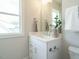 Bathroom featuring a single vanity with a white countertop, ample natural light, and sleek fixtures at 921 Lily Claire Ln, Fuquay Varina, NC 27526