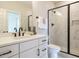 Bathroom with a dual-sink vanity, matte black fixtures, and a glass enclosed shower with marble tile at 921 Lily Claire Ln, Fuquay Varina, NC 27526