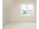 Carpeted bedroom featuring large windows with exterior view and neutral colors at 921 Lily Claire Ln, Fuquay Varina, NC 27526