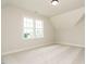 Bedroom with neutral carpet, large window, and dormer-style ceiling detail at 921 Lily Claire Ln, Fuquay Varina, NC 27526