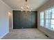 Dining room featuring a modern chandelier, a decorative accent wall, and large windows at 921 Lily Claire Ln, Fuquay Varina, NC 27526