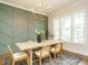 Chic dining room with modern light fixture, decorative wall, and large windows at 921 Lily Claire Ln, Fuquay Varina, NC 27526