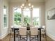Dining area with modern chandelier, table and chairs, and view to landscaped backyard at 921 Lily Claire Ln, Fuquay Varina, NC 27526