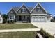 Charming gray two-story home featuring a landscaped front yard, covered porch, and two-car garage at 921 Lily Claire Ln, Fuquay Varina, NC 27526